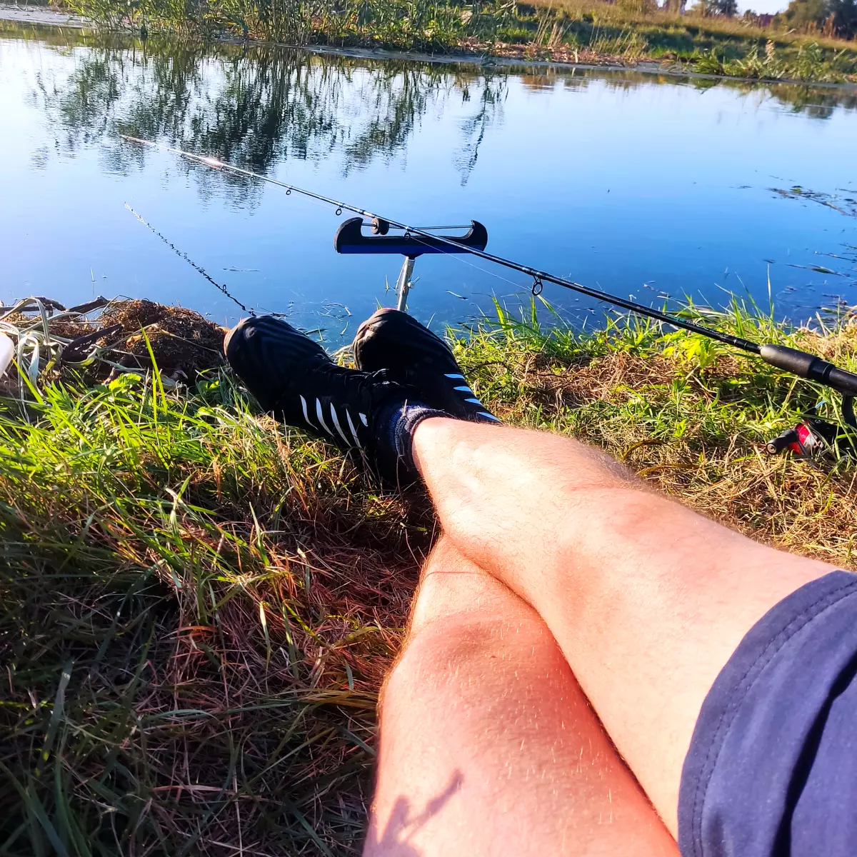 Angler döst am Ufer eines kleines Flusses