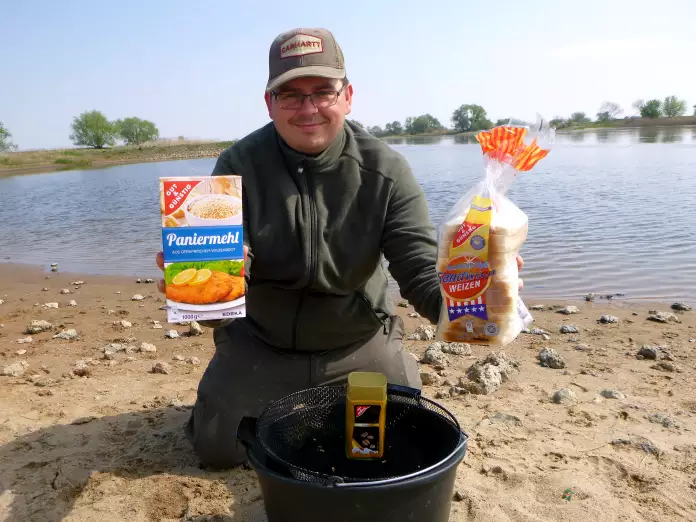 Angler mischt Grundfutter Rezept am Fluss an